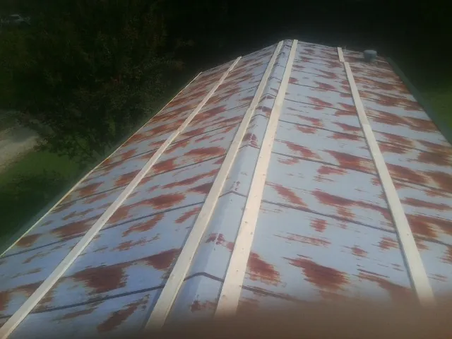 Rusted metal roof panels with new wood purlins before replacement — Storm Damage Roof Repair in Coyle by Roofing Brothers