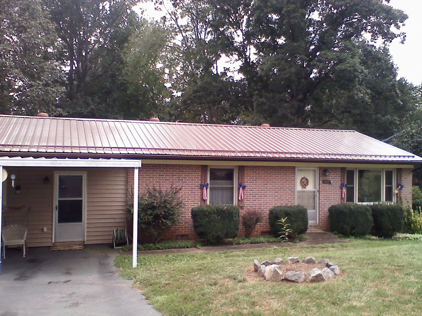 Bronze metal roof and carport on a brick ranch home — Roof Repair work by our crew in Coyle