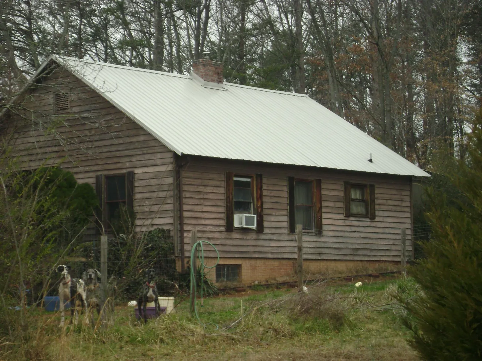 White metal roof on an old wood sided farmhouse, from a Metal Roof Installation job in Coyle